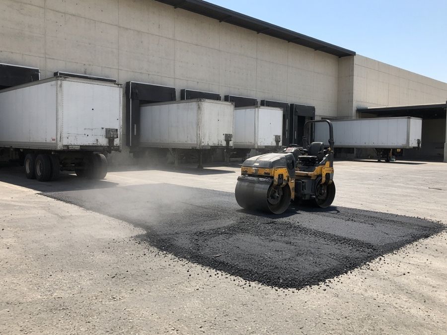 Thick asphalt lift being rolled in a warehouse truck court — asphalt paving in Riverside, CA